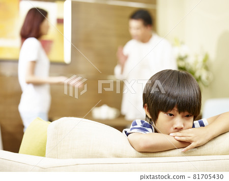 asian child appears sad and unhappy while parents quarreling in the background asian child appears sad and unhappy while parents quarreling in the background 81705430