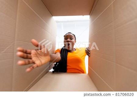 Bottom view of overjoyed black woman receiving online order, unboxing carton parcel indoors Bottom view of overjoyed black woman receiving online order, unboxing carton parcel indoors 81706020