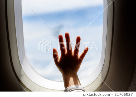 cute toddler points his finger at the sky through the window. first flight concept, traveling with children 81706027