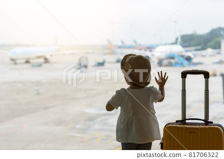 Baby looking at the plane in airport 81706322