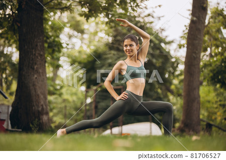 Full-length potrait of young sportive slim woman practising yoga on open air 81706527