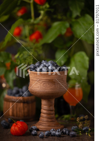 Blueberries in a ceramic bowl against a background of physalis Blueberries in a ceramic bowl against a background of physalis 81707011