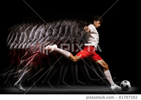 Young professional football player training isolated on black background. Stroboscope effect 81707302