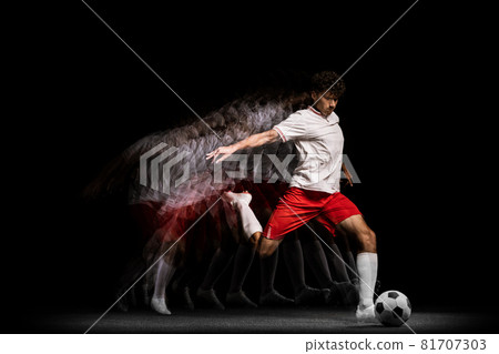 Young professional football player training alone isolated on black background. Stroboscope effect 81707303