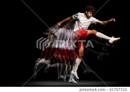 Stroboscope effect. Professional football player isolated on black background playing 81707310