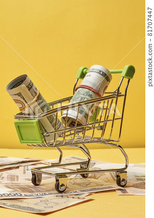 Buying us dollars in Uzbekistan. US dollars roll in shopping trolley and pile of Uzbek sums. Uzbek money and us dollar money exchange 81707447