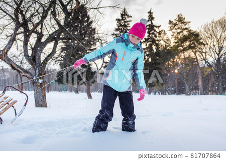 Teengae girl having fun playing with the sledge in the snow in winter Teengae girl having fun playing with the sledge in the snow in winter 81707864