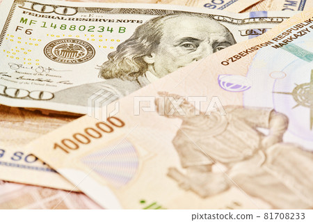 US dollar banknote and Uzbek sums. Concept of exchange rate, Uzbek sum to us dollar. Money exchange in Uzbekistan. Pile of Uzbek money sum and American dollar bill 81708233