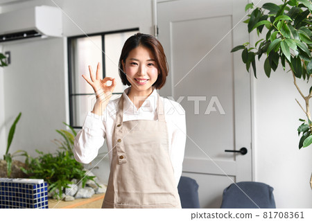 A young woman in a smiling apron indoors A young woman in a smiling apron indoors 81708361