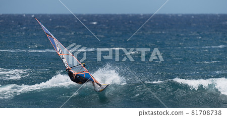 Windsurfer surfing the wind on waves in ocean sea 81708738