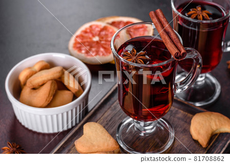 Christmas mulled red wine with spices and fruits on a dark table. 81708862