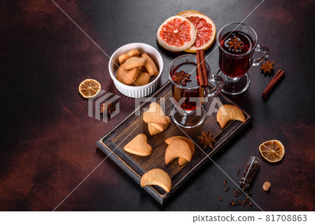 Christmas mulled red wine with spices and fruits on a dark table. 81708863