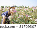 Beautiful woman relaxing in a beautiful flower field watching the sunset. 81709307