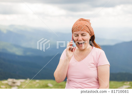 Young female traveler talking on the phone in the mountains. Connectivity mobility technology. Travel Lifestyle sport and extreme, adventure activities. Young female traveler talking on the phone in the mountains. Connectivity mobility technology. Travel Lifestyle sport and extreme, adventure activities. 81710081