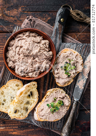 Toasts with Duck pate Rillettes de Canard on wooden board. Dark wooden background. Top View Toasts with Duck pate Rillettes de Canard on wooden board. Dark wooden background. Top View 81712774