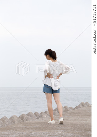 夏日早晨，一位女士在防波堤上散步 81715711