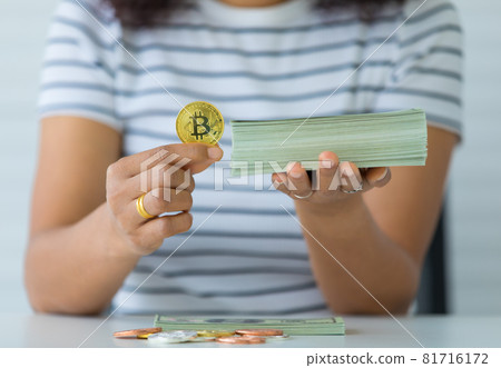 Hands holding crypto coin and stack of banknotes money and the comparison gesture. Concept of investment in digital assets and old-school treasure 81716172
