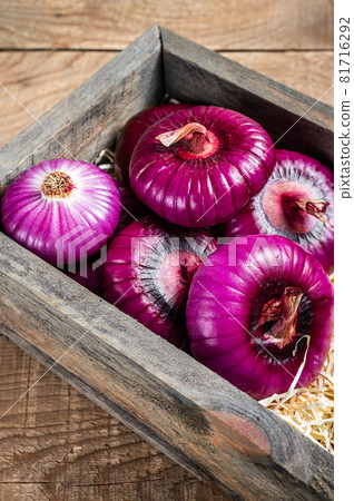 Flat red sweet onion in wooden box. Wooden background. Top View Flat red sweet onion in wooden box. Wooden background. Top View 81716292