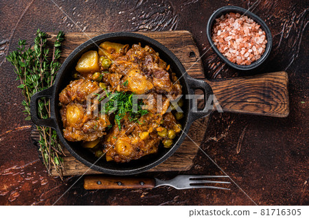 Beef oxtails stew with wine and vegetables in a pan. Dark background. Top view Beef oxtails stew with wine and vegetables in a pan. Dark background. Top view 81716305