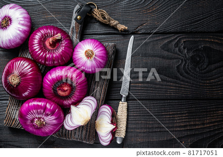 Whole and halfed Flat red sweet onion on a cutting board. Black Wooden background. Top View. Copy space Whole and halfed Flat red sweet onion on a cutting board. Black Wooden background. Top View. Copy space 81717051