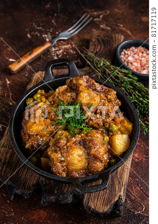 Beef oxtails stew with wine and vegetables in a pan. Dark background. Top view Beef oxtails stew with wine and vegetables in a pan. Dark background. Top view 81717119