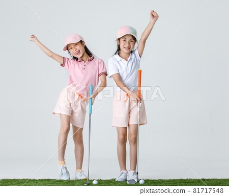 Portrait isolated studio shot of two Asian little professional girl golfers in athlete fashion clothing stand smile hold fist up overhead when receive victory win in game in front white background Portrait isolated studio shot of two Asian little professional girl golfers in athlete fashion clothing stand smile hold fist up overhead when receive victory win in game in front white background 81717548