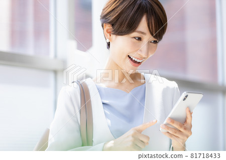 A woman operating a smartphone app on the go A woman operating a smartphone app on the go 81718433