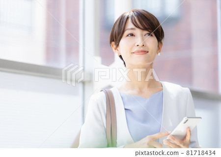 A woman operating a smartphone app on the go A woman operating a smartphone app on the go 81718434