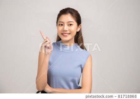 Thinking asian woman stand up isolated on white background.Asian female model smiling looking up.woman pointing fingers away on white background isolated. Thinking asian woman stand up isolated on white background.Asian female model smiling looking up.woman pointing fingers away on white background isolated. 81718868