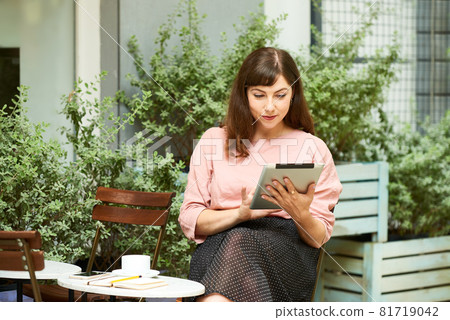 Young Woman Reading News Article Young Woman Reading News Article 81719042