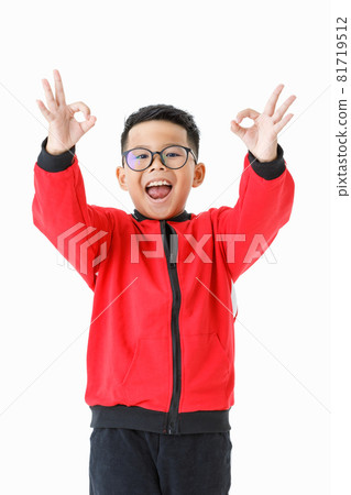 Cutout portrait of smart young healthy Asian boy on red jacket and black pants happily standing and raising hands up to express OK sign with smile and fun as satisfying good opportunity Cutout portrait of smart young healthy Asian boy on red jacket and black pants happily standing and raising hands up to express OK sign with smile and fun as satisfying good opportunity 81719512
