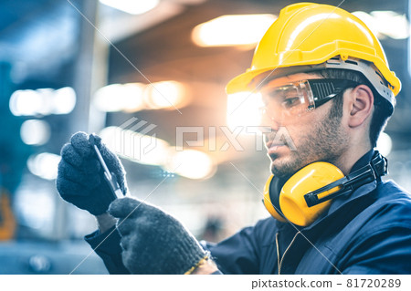 Industrial Engineers in Hard Hats.Work at the Heavy Industry Manufacturing Factory.industrial worker indoors in factory. man working in an industrial factory.Safety first concept. Industrial Engineers in Hard Hats.Work at the Heavy Industry Manufacturing Factory.industrial worker indoors in factory. man working in an industrial factory.Safety first concept. 81720289