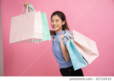 Asian pretty young woman sitting on pink pastel background. She smiling and happy shopping bags. she nice-looking lovely attractive shine She holding mobile. Asian pretty young woman sitting on pink pastel background. She smiling and happy shopping bags. she nice-looking lovely attractive shine She holding mobile. 81720418