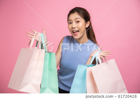 Asian pretty young woman sitting on pink pastel background. She smiling and happy shopping bags. she nice-looking lovely attractive shine She holding mobile. Asian pretty young woman sitting on pink pastel background. She smiling and happy shopping bags. she nice-looking lovely attractive shine She holding mobile. 81720428