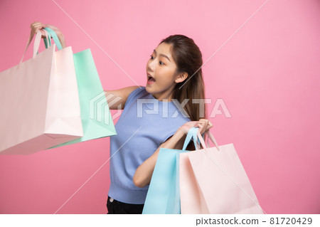 Asian pretty young woman sitting on pink pastel background. She smiling and happy shopping bags. she nice-looking lovely attractive shine She holding mobile. Asian pretty young woman sitting on pink pastel background. She smiling and happy shopping bags. she nice-looking lovely attractive shine She holding mobile. 81720429
