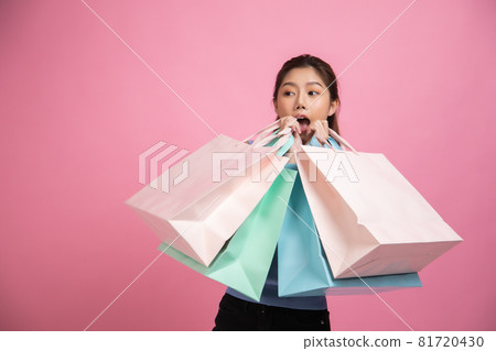 Asian pretty young woman sitting on pink pastel background. She smiling and happy shopping bags. she nice-looking lovely attractive shine She holding mobile. Asian pretty young woman sitting on pink pastel background. She smiling and happy shopping bags. she nice-looking lovely attractive shine She holding mobile. 81720430