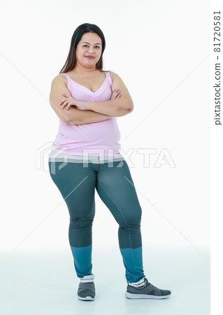 Portrait isolated studio shot of Asian happy healthy strong big fat oversize chubby pretty girl in sport clothing leggings pants standing look at camera smiling crossed arms on white background Portrait isolated studio shot of Asian happy healthy strong big fat oversize chubby pretty girl in sport clothing leggings pants standing look at camera smiling crossed arms on white background 81720581