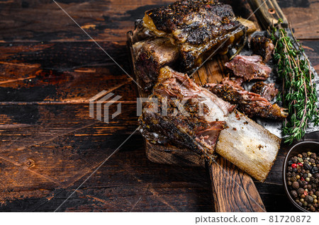 BBQ short chuck beef ribs with herbs and meat cleaver. Dark wooden background. Top view. Copy space BBQ short chuck beef ribs with herbs and meat cleaver. Dark wooden background. Top view. Copy space 81720872