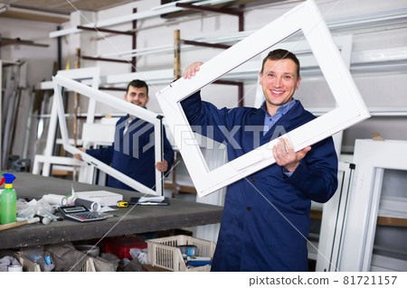 Two cheerful men professional labours with finished PVC profiles and windows Two cheerful men professional labours with finished PVC profiles and windows 81721157