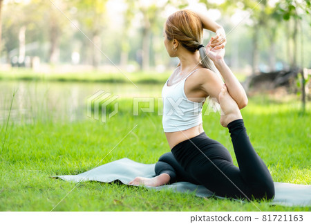 Young asian woman practicing yoga in garden.female happiness. blurred background.Healthy lifestyle and relaxation concept.Young Asian Girl doing yoga in the park. Young asian woman practicing yoga in garden.female happiness. blurred background.Healthy lifestyle and relaxation concept.Young Asian Girl doing yoga in the park. 81721163