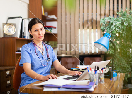 Experienced Asian female therapist working with laptop in office 81721167