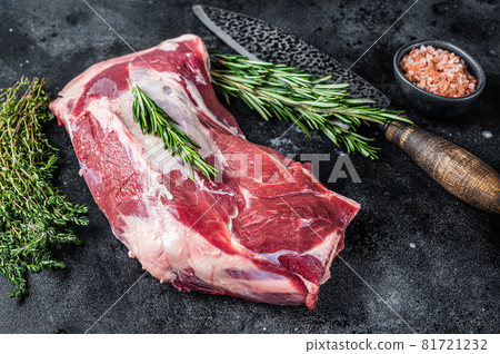 Fresh Raw lamb mutton shoulder meat with butcher knife. Black background. Top view 81721232