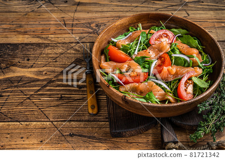 Vegetable salad with smoked salmon, arugula, tomato and green vegetables. wooden background. Top View. Copy space 81721342