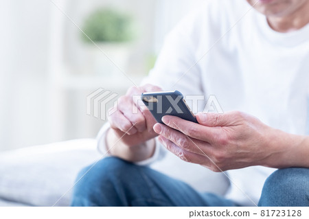 Hands of middle-aged men looking at smartphones 81723128