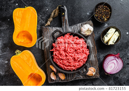Raw mince meat, pumpkin with garlic and onion. Black background. Top view Raw mince meat, pumpkin with garlic and onion. Black background. Top view 81723155