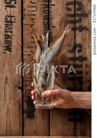 Male hand holding glass with air-dried salted sabrefish Male hand holding glass with air-dried salted sabrefish 81724466