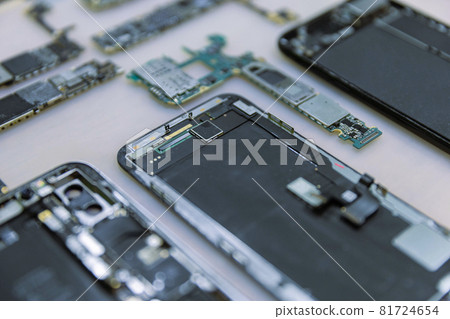 Phone repair concept several electronic devices taken apart into the components like the covers, circuit boards, bodies 81724654