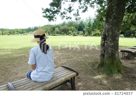 一個女孩坐在大公園長凳上的背影 一個女孩坐在大公園長凳上的背影 81724857
