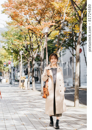 A woman wearing a trench coat and bra in the city 81724880