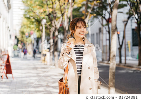 A woman wearing a trench coat and bra in the city A woman wearing a trench coat and bra in the city 81724881
